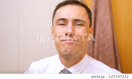 Businessman smiling wearing shirt and tie in bathroom 125747232
