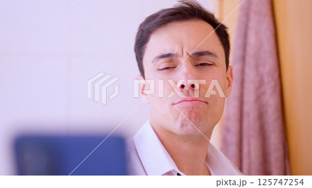 Businessman taking a selfie in bathroom mirror with funny expression 125747254