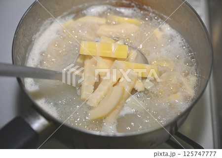 生の筍(たけのこ、タケノコ、竹の子)を、鍋で米の研ぎ汁で下茹でする。 生の筍(たけのこ、タケノコ、竹の子)を、鍋で米の研ぎ汁で下茹でする。 125747777