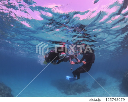 石垣島の青い海でシュノーケルを楽しむ家族 125748079