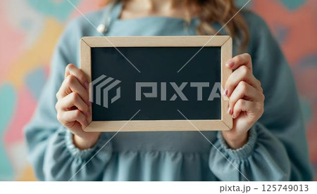 A woman proudly displays a blackboard, celebrating empowerment on International Women's Day 125749013