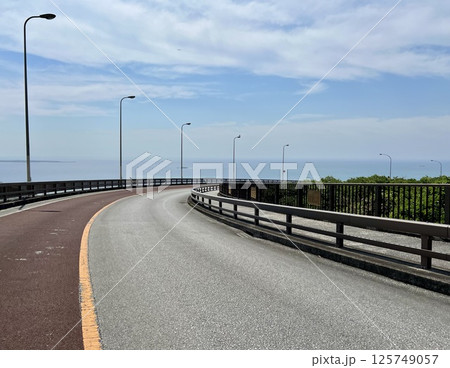海へと続くカーブ道路と青空の風景 海へと続くカーブ道路と青空の風景 125749057