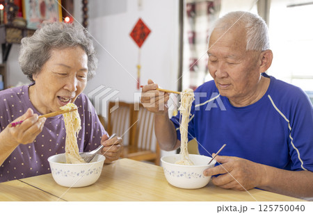 Happy Asian Elderly couple eating noodles at home 125750040