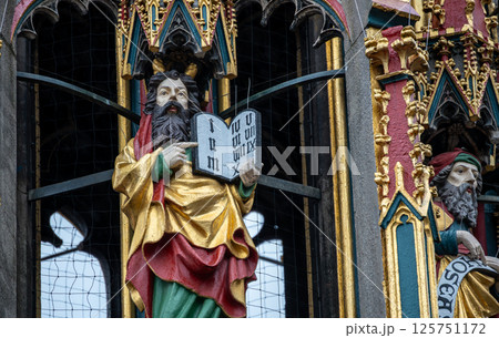 Nuremberg, Germany, August 2, 2023. Detail of one of the many statues that characterize the golden fountain in the market square. Travel destinations and tourist attractions. 125751172