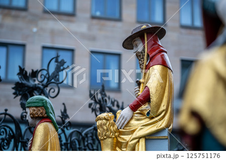 Nuremberg, Germany, August 2, 2023. Detail of one of the many statues that characterize the golden fountain in the market square. Travel destinations and tourist attractions. Nuremberg, Germany, August 2, 2023. Detail of one of the many statues that characterize the golden fountain in the market square. Travel destinations and tourist attractions. 125751176