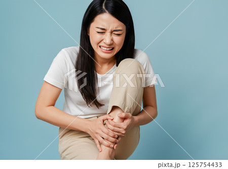 足のすねをぶつけて痛がっている女性 足のすねをぶつけて痛がっている女性 125754433
