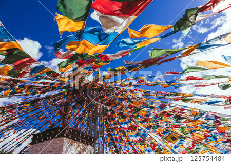 The Changqing Chunker Temple in Litang, China. Many colourful prayer flags on the mountain top beside the temple.Spirituality and meditation. The Changqing Chunker Temple in Litang, China. Many colourful prayer flags on the mountain top beside the temple.Spirituality and meditation. 125754484