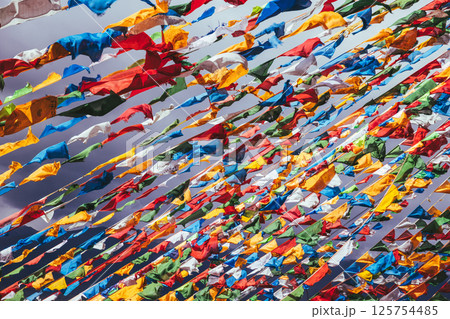 The Changqing Chunker Temple  in Litang, China. Many colourful prayer flags on the mountain top beside the temple.Spirituality and meditation. 125754485