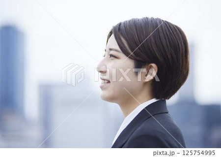 スーツを着た若い日本人女性と都会の街並み 125754995