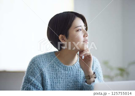 ペンを手に窓の外を見ながら考える女子大学生 125755014