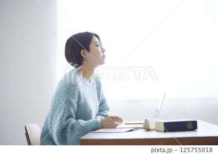 自宅学習中に窓を見上げる女子大学生の横顔 自宅学習中に窓を見上げる女子大学生の横顔 125755018