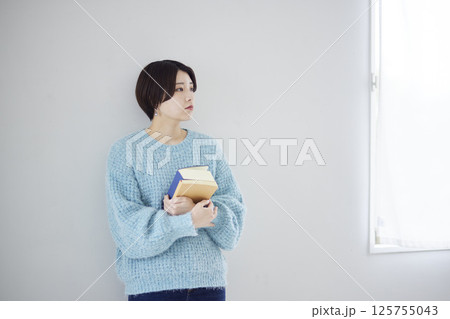 辞書と参考書を抱き抱えた大学生 125755043