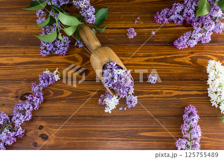 Purple lilac on top on wooden surface in wooden scoop Purple lilac on top on wooden surface in wooden scoop 125755489
