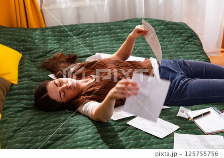 Young Caucasian woman working on financial stability, checking invoices, and managing family budget. Economy and financial management. Top view, mid shot 125755756