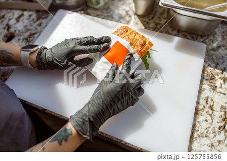 Food Preparation Carefully Wrapping a Fresh and Delicious Sandwich with Attention and Care 125755856