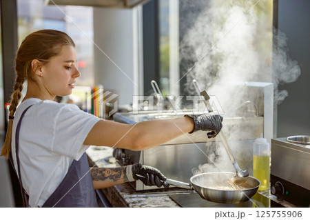 A Culinary Expert is skillfully Cooking in a Modern Kitchen while utilizing Steam technology A Culinary Expert is skillfully Cooking in a Modern Kitchen while utilizing Steam technology 125755906