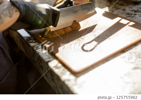 An Expert Chef Skillfully Slicing Fresh Ingredients with Precision and Care in the Kitchen 125755982