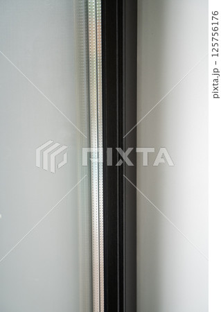 Macro photo of double-glazed window with perforated spacer and dark profile 125756176
