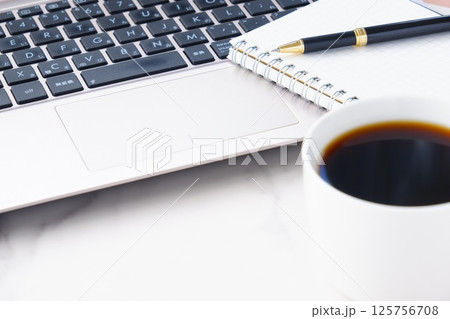 コーヒーを飲みながら、ノートパソコンでデスクワークをしているイメージ コーヒーを飲みながら、ノートパソコンでデスクワークをしているイメージ 125756708