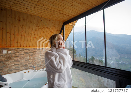 Beautiful woman in white bathrobe looking on the mountains in Variaki, Georgia 125757787