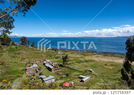 Scenic view of Lake Titicaca from Llachon with rural houses Scenic view of Lake Titicaca from Llachon with rural houses 125758397