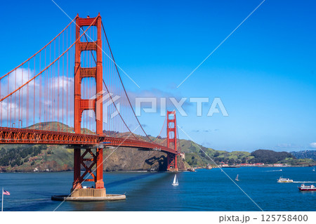 Golden Gate Bridge over blue waters with scenic hills in San Francisco Golden Gate Bridge over blue waters with scenic hills in San Francisco 125758400