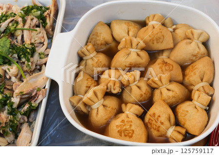 close up of a big pot of boiled Japanese tofu (bean curd) pouches with rice cake (mochi kinchaku) with a Japanese word "Luck" on it close up of a big pot of boiled Japanese tofu (bean curd) pouches with rice cake (mochi kinchaku) with a Japanese word "Luck" on it 125759117