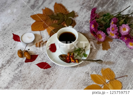 Autumn, fall leaves, hot steaming cup of coffee and a warm scarf on wooden table background. Seasonal, morning coffee, Sunday relaxing and still life concept. Autumn, fall leaves, hot steaming cup of coffee and a warm scarf on wooden table background. Seasonal, morning coffee, Sunday relaxing and still life concept. 125759757