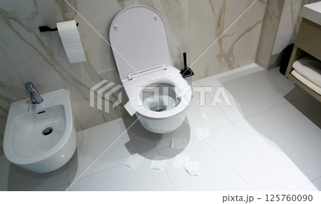 A public toilet with scattered hygiene paper showing failed sanitary attempt A public toilet with scattered hygiene paper showing failed sanitary attempt 125760090