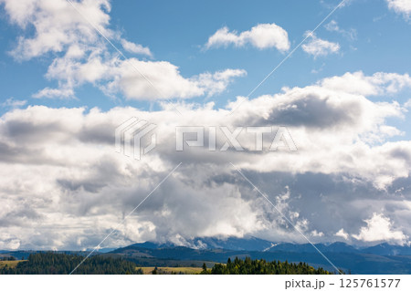 heavy clouds on a blue sky above mountains september. dramatic view. early autumn cloudy weather over carpathian range. ukraine climate heavy clouds on a blue sky above mountains september. dramatic view. early autumn cloudy weather over carpathian range. ukraine climate 125761577