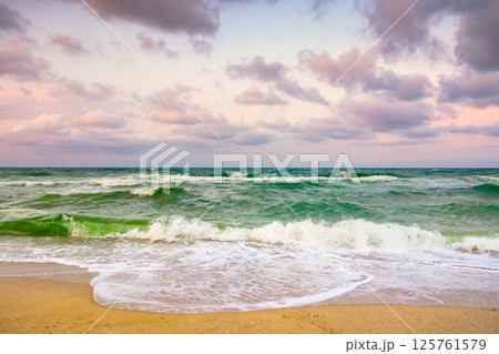 cloudy evening sky at the black sea. rolling waves. weather change in nature. beautiful orange cloudscape. dramatic summer vacation in europe at the beach cloudy evening sky at the black sea. rolling waves. weather change in nature. beautiful orange cloudscape. dramatic summer vacation in europe at the beach 125761579