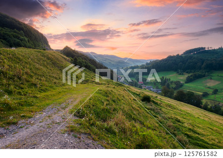 rural landscape in summer. organic farmland.village in the valley at dawn. forest and green meadow on the hill under red sky. scenic view of a countryside in mountains of ukraine rural landscape in summer. organic farmland.village in the valley at dawn. forest and green meadow on the hill under red sky. scenic view of a countryside in mountains of ukraine 125761582