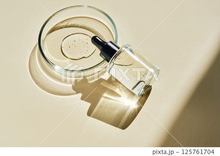 Oil essence for the face on a beige background. 125761704