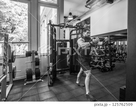 Youbng strong Man training in GYM on exercise machine Youbng strong Man training in GYM on exercise machine 125762509
