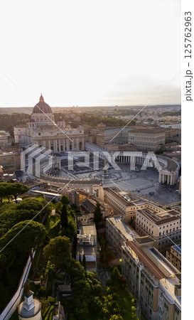 Aerial view of St. Peters Basilica and St. Peters Square in Vatican City at sunset, with surrounding architecture and gardens visible in warm evening light. Aerial view of St. Peters Basilica and St. Peters Square in Vatican City at sunset, with surrounding architecture and gardens visible in warm evening light. 125762963