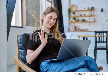 Young woman using laptop for video call, online chat conference sitting at home Young woman using laptop for video call, online chat conference sitting at home 125763119