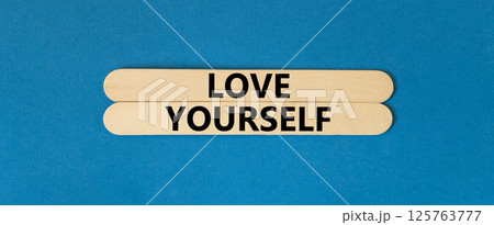 Love yourself symbol. Concept words Love yourself on beautiful wooden stick. Beautiful blue table blue background. Psychology love yourself concept. Copy space. 125763777