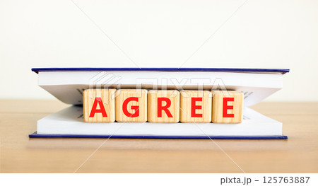 Agree symbol. Concept word Agree on beautiful wooden blocks in book. Beautiful wooden table white background. Business agree concept. Copy space. Agree symbol. Concept word Agree on beautiful wooden blocks in book. Beautiful wooden table white background. Business agree concept. Copy space. 125763887