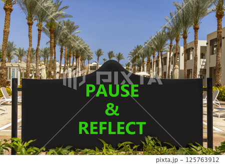 Pause and reflect symbol. Concept words Pause and reflect on beautiful big black road sign. Beautiful palm tree hotel background. Business motivational lifestyle pause and reflect concept. Copy space. 125763912