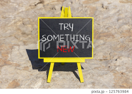 Try something new symbol. Concept words Try something new on beautiful blackboard. Beautiful brown stone beach background. Business motivational lifestyle try something new concept. Copy space. 125763984