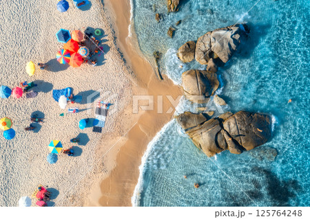 Aerial view of colorful umbrellas, sandy beach and blue sea Aerial view of colorful umbrellas, sandy beach and blue sea 125764248