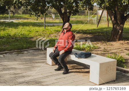Man In The Park Of The City Relaxing On The Bench Man In The Park Of The City Relaxing On The Bench 125765169