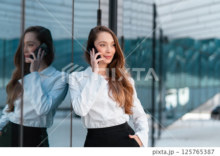 Smiling businesswoman with brown hair talking on Smiling businesswoman with brown hair talking on 125765387