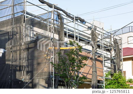 住宅の外壁塗装のための足場とネット 125765811