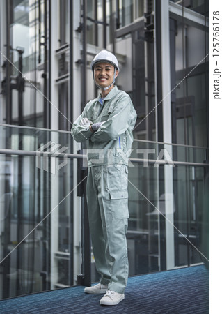 カメラ目線で腕組みをした作業服姿の40代の男性　ビルメンテナンススタッフ　イメージ　 125766178