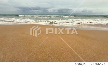 A Beautiful Tranquil Beach Landscape Under a Dramatic and Moody Sky Above It All 125766573