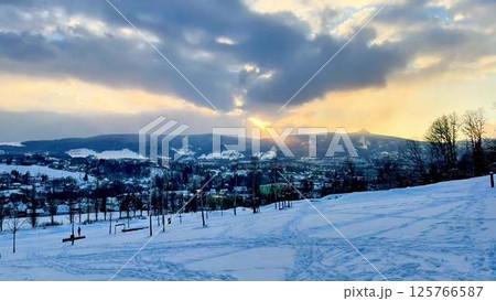 A Beautiful and Serene Winter Landscape Featuring a Vibrant Sunset Over SnowCovered Hills A Beautiful and Serene Winter Landscape Featuring a Vibrant Sunset Over SnowCovered Hills 125766587