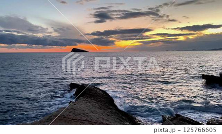 Incredible and Stunning Sunset Over the Ocean with Beautiful Dramatic Clouds in the Sky 125766605