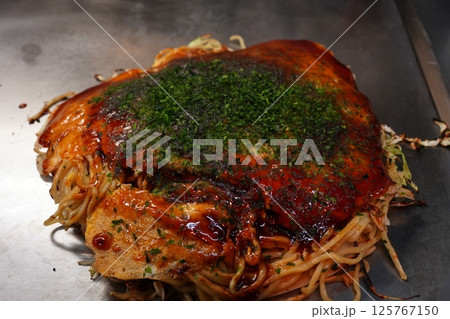 鉄板で焼いてる調理中の大阪名物お好み焼き 125767150