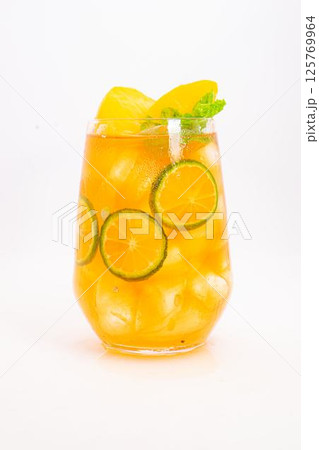 yellow peach and orange citrus drink with fresh mint leaves and ice served in clear glass on white background. High quality photo yellow peach and orange citrus drink with fresh mint leaves and ice served in clear glass on white background. High quality photo 125769964